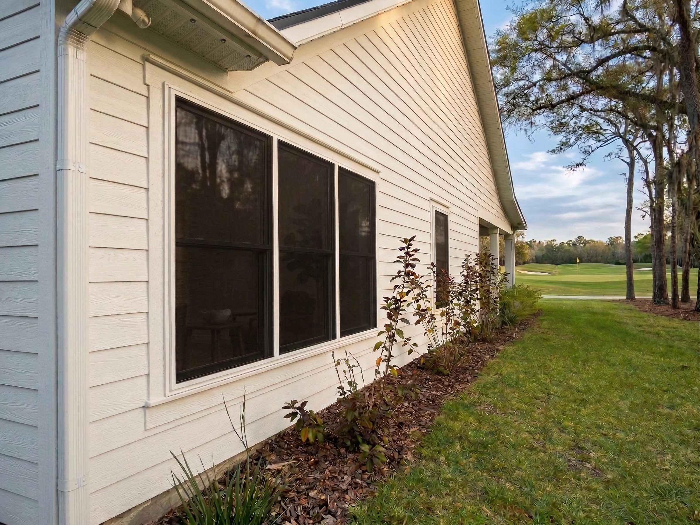 Home along a Florida golf course fairway with Fortress impact screens on its windows