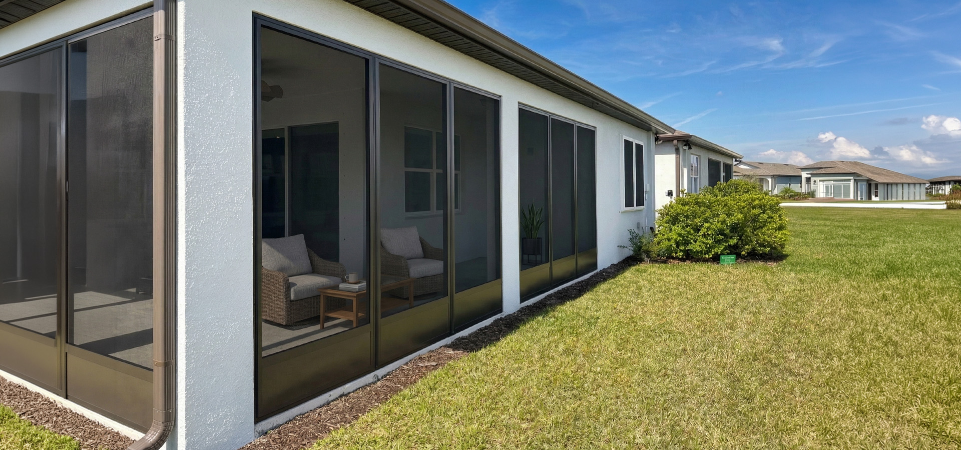 Fortress Screens custom screen enclosure with bronze frames on a Florida home