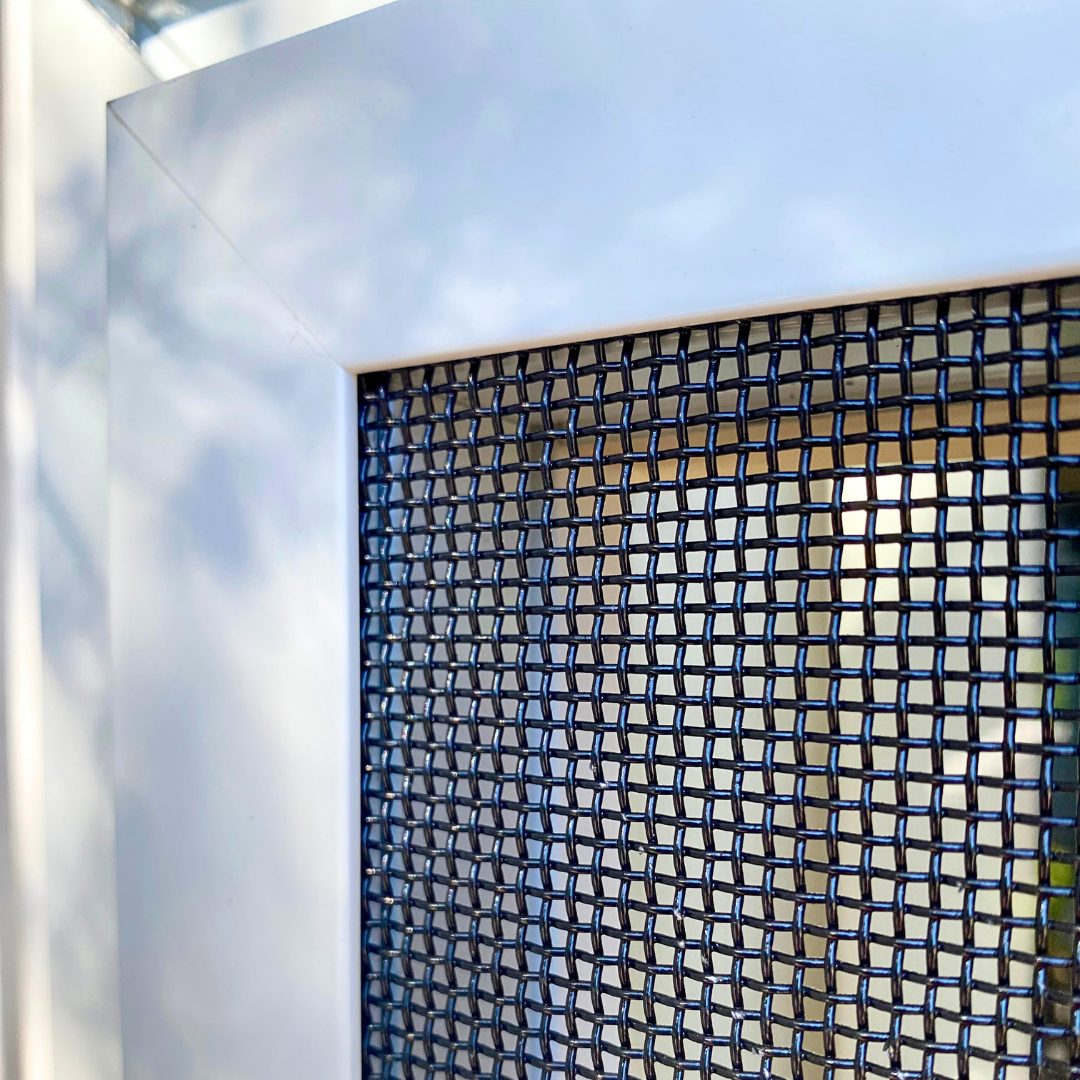 Close-up of the corner of a Fortress screen showing stainless steel mesh set in an aluminum frame