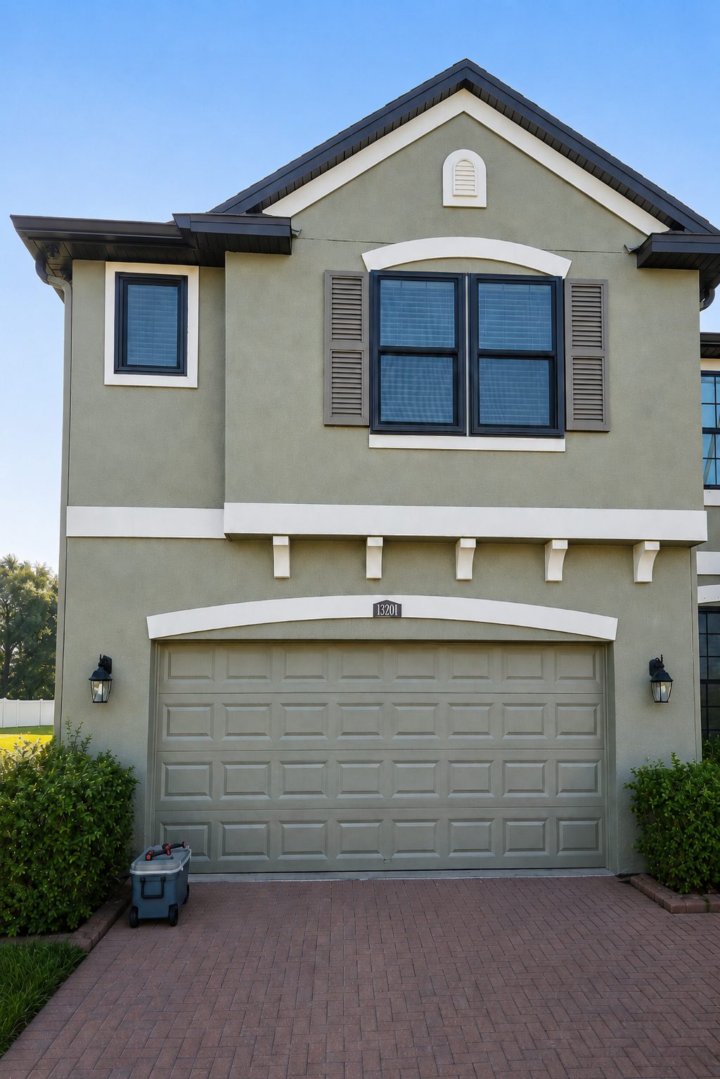 Landscaped two-story Florida home with arched windows and a paved driveway