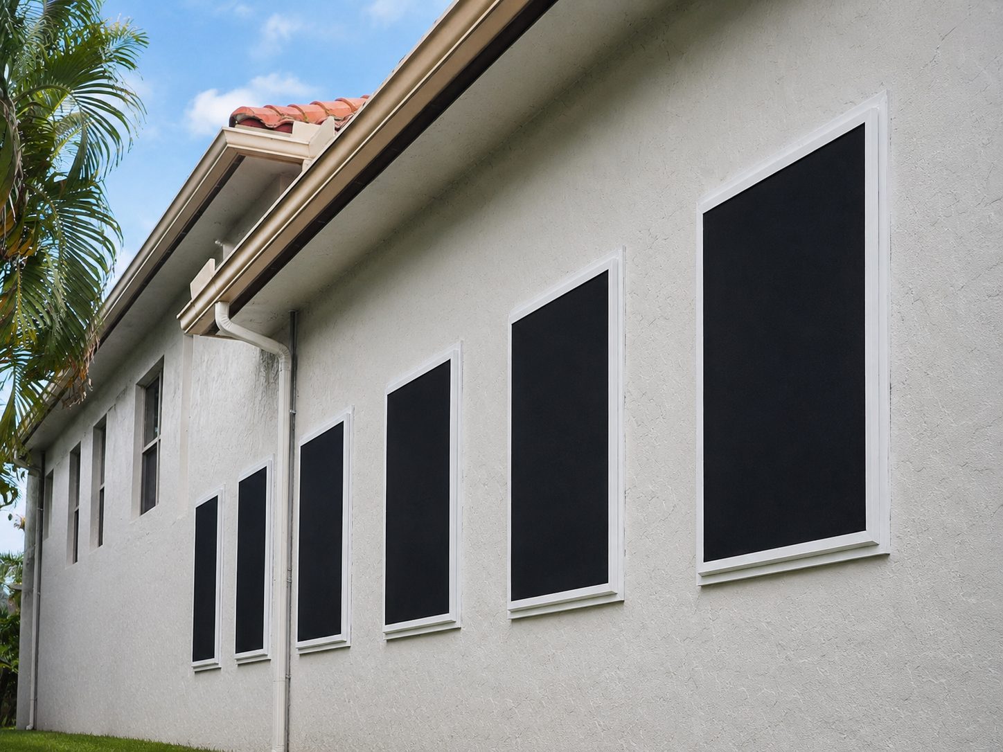 Window detail on a white stucco home showing Fortress stainless steel screens