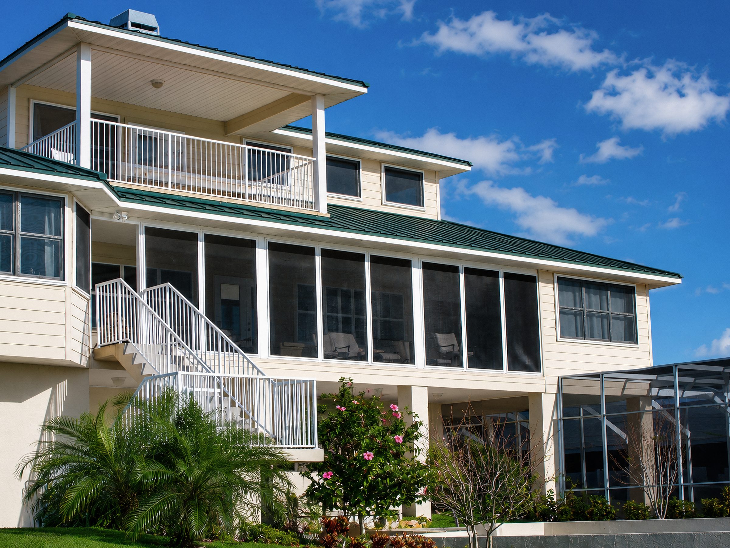 Yellow Florida home front elevation with Fortress screens installed on windows and entry