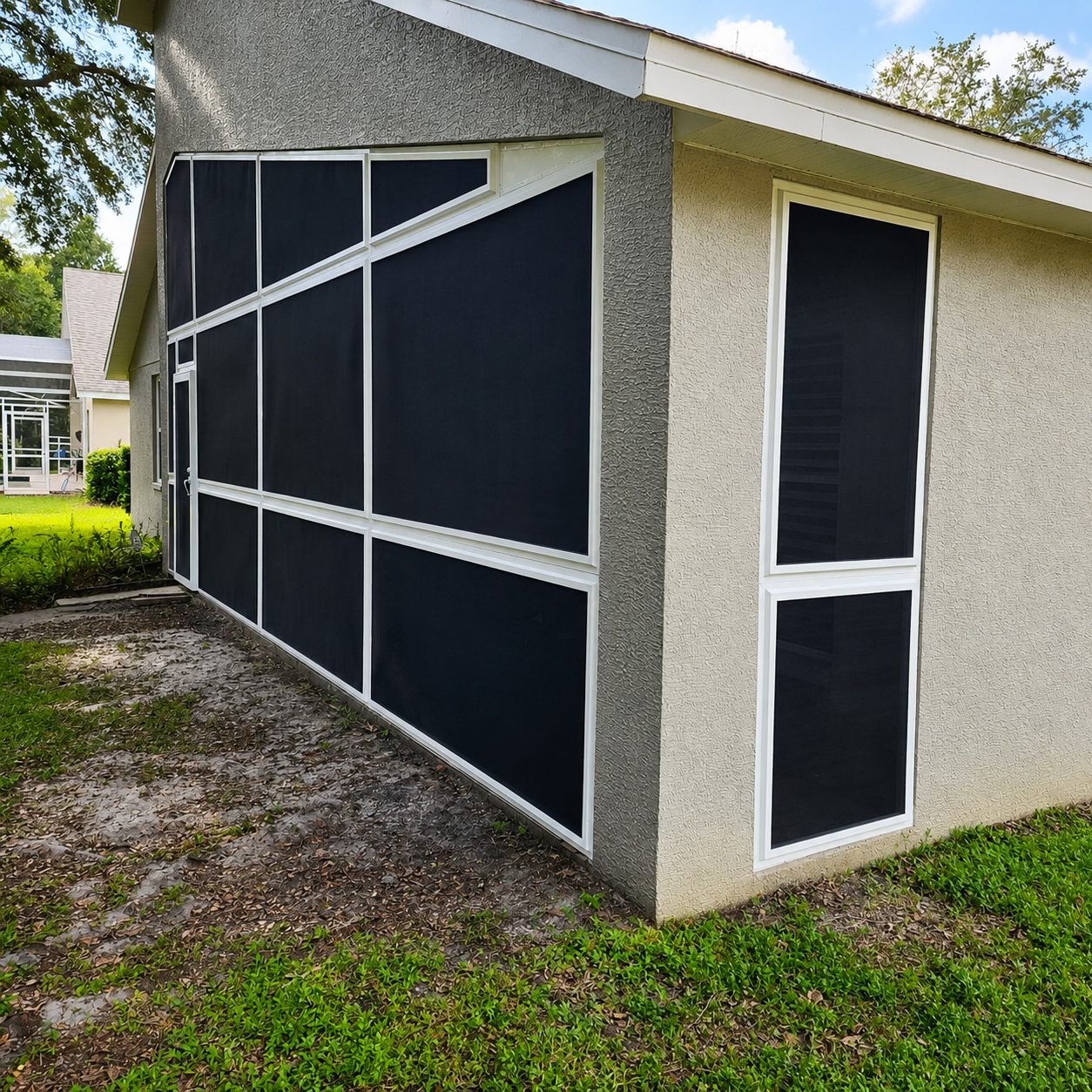 Grey Florida home with custom Fortress screen panels fitted to angular wall openings
