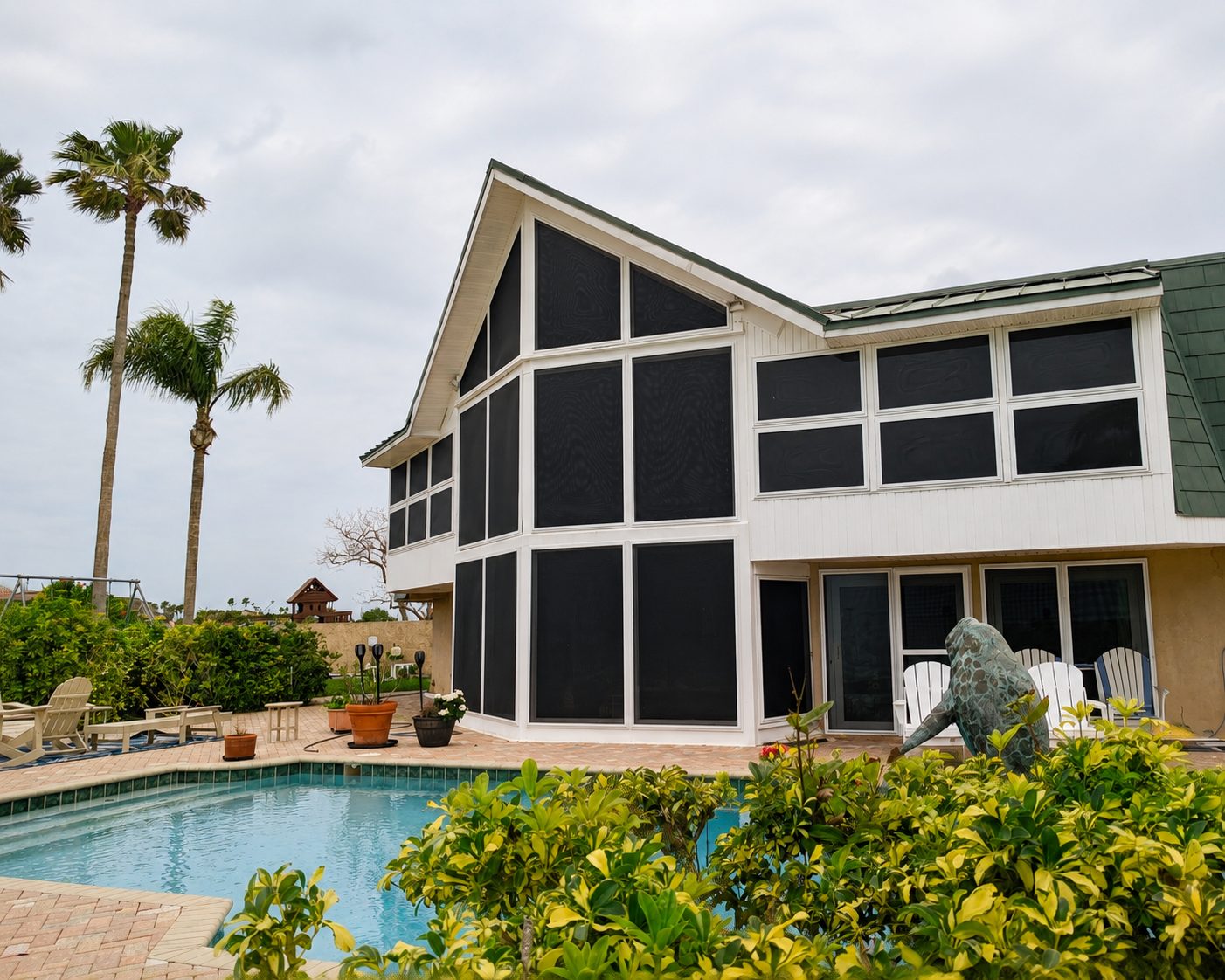 Poolside Florida home with dark Fortress screens installed across multiple windows