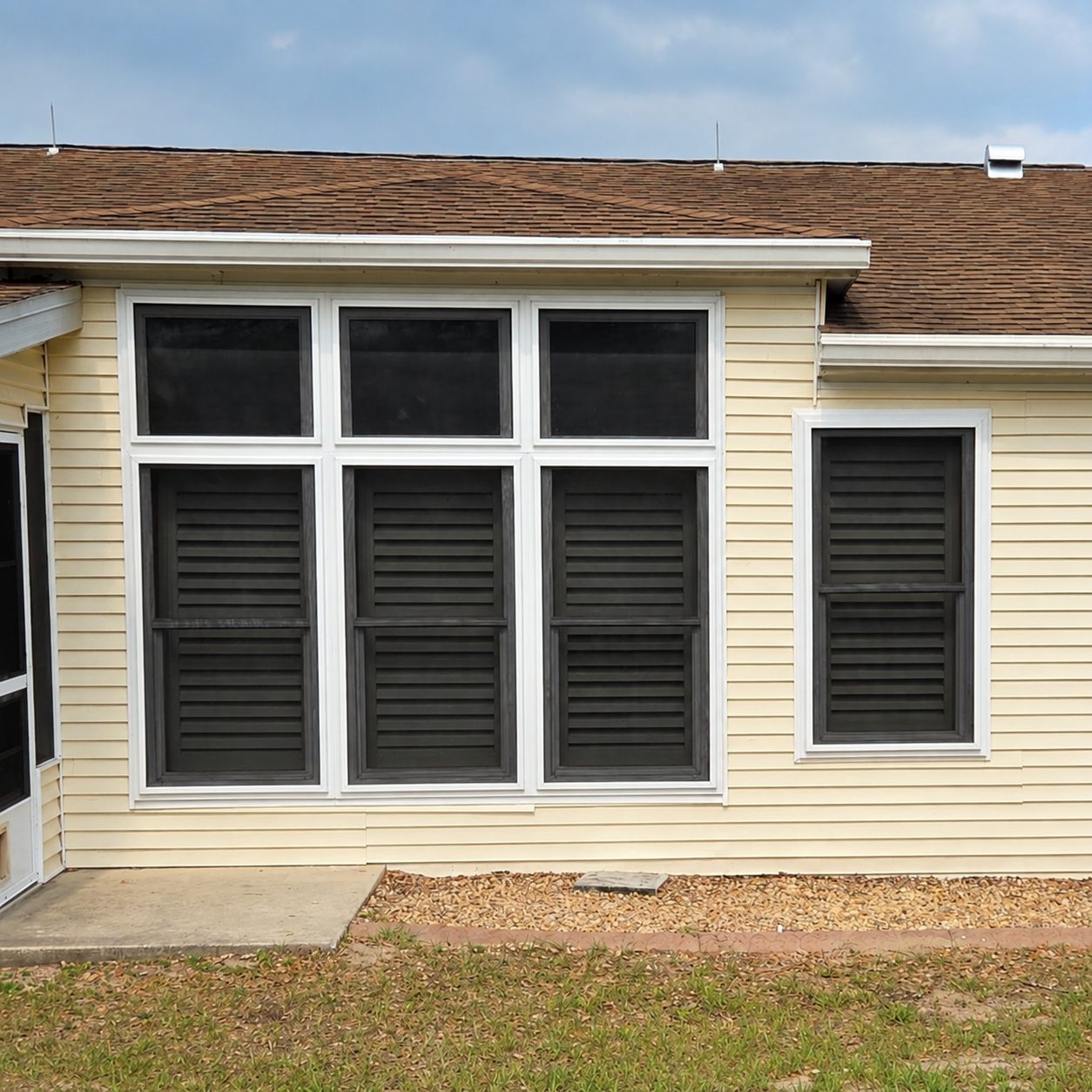 Completed dark Fortress screens installed across residential window openings