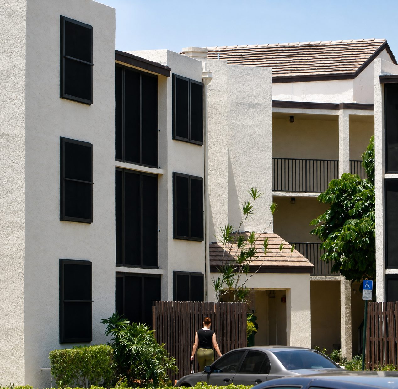 Three-story apartment building with dark Fortress screens installed across multiple windows